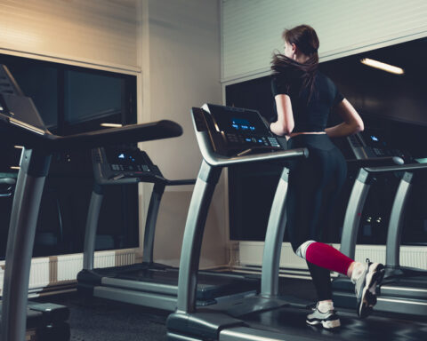 Mulher pratica um treino hiit na esteira em uma academia