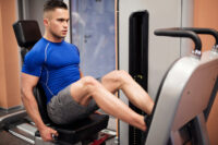 Homem treinando na academia em um equipamento de leg press, fortalecendo as pernas durante o "leg day"